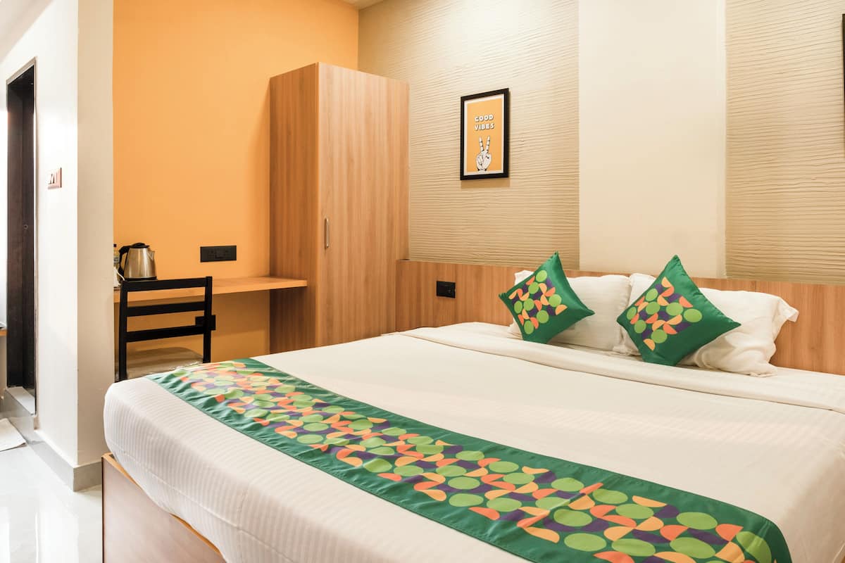 Een hotelkamer met een bed, een bureau en een kledingkast.