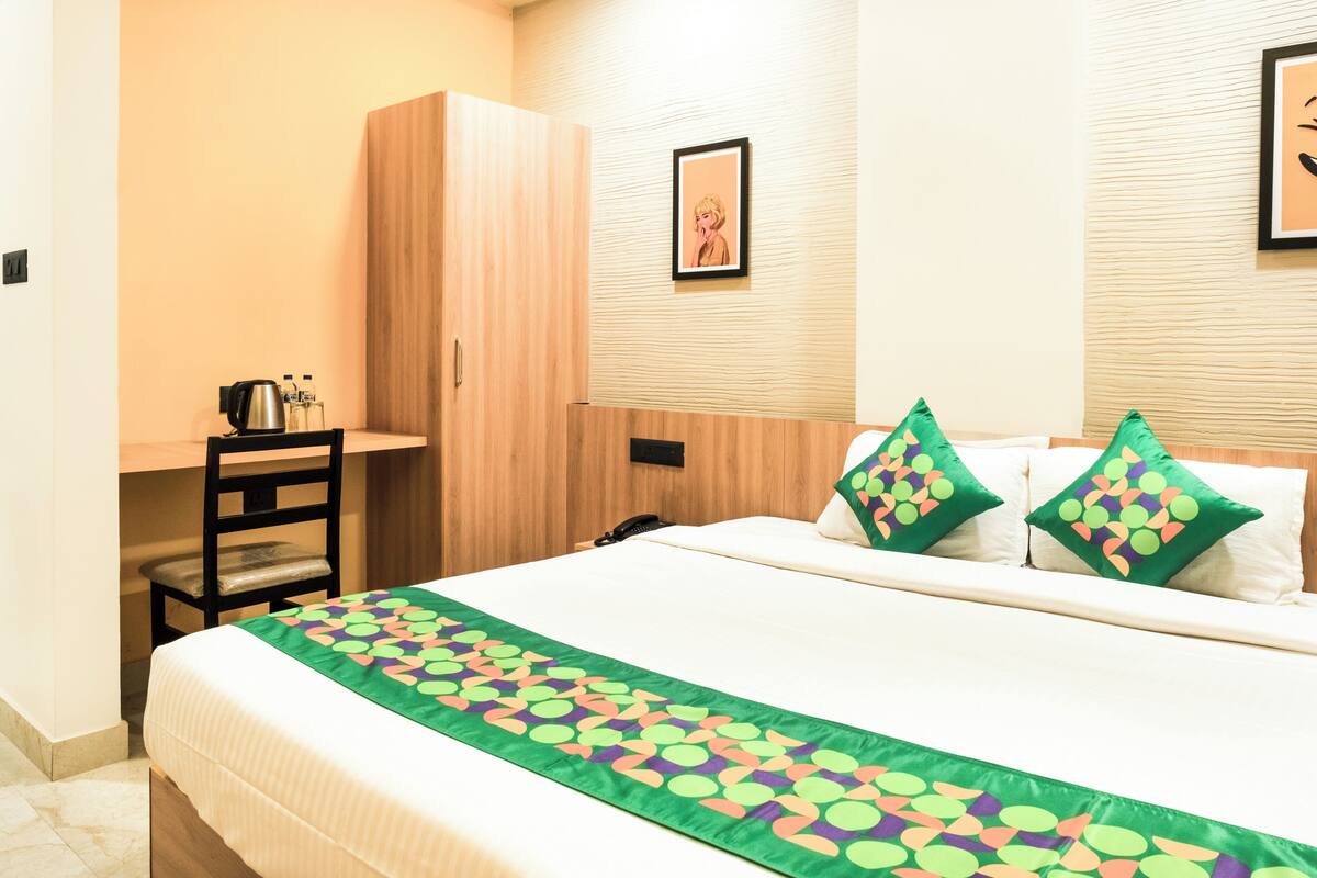 Een hotelkamer met een bed, een bureau en een kledingkast.