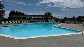 A swimming pool with lounge chairs and a covered seating area. - Waterfront Lake Gaston Retreat with beautiful views, Gameroom and covered deck. (Bracey)
