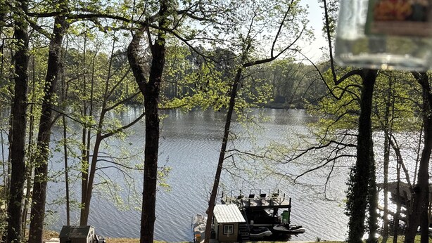 A lakeside cabin with a dock, surrounded by trees and a clear view of the lake. - Waterfront Lake Gaston Retreat with beautiful views, Gameroom and covered deck. (Bracey)