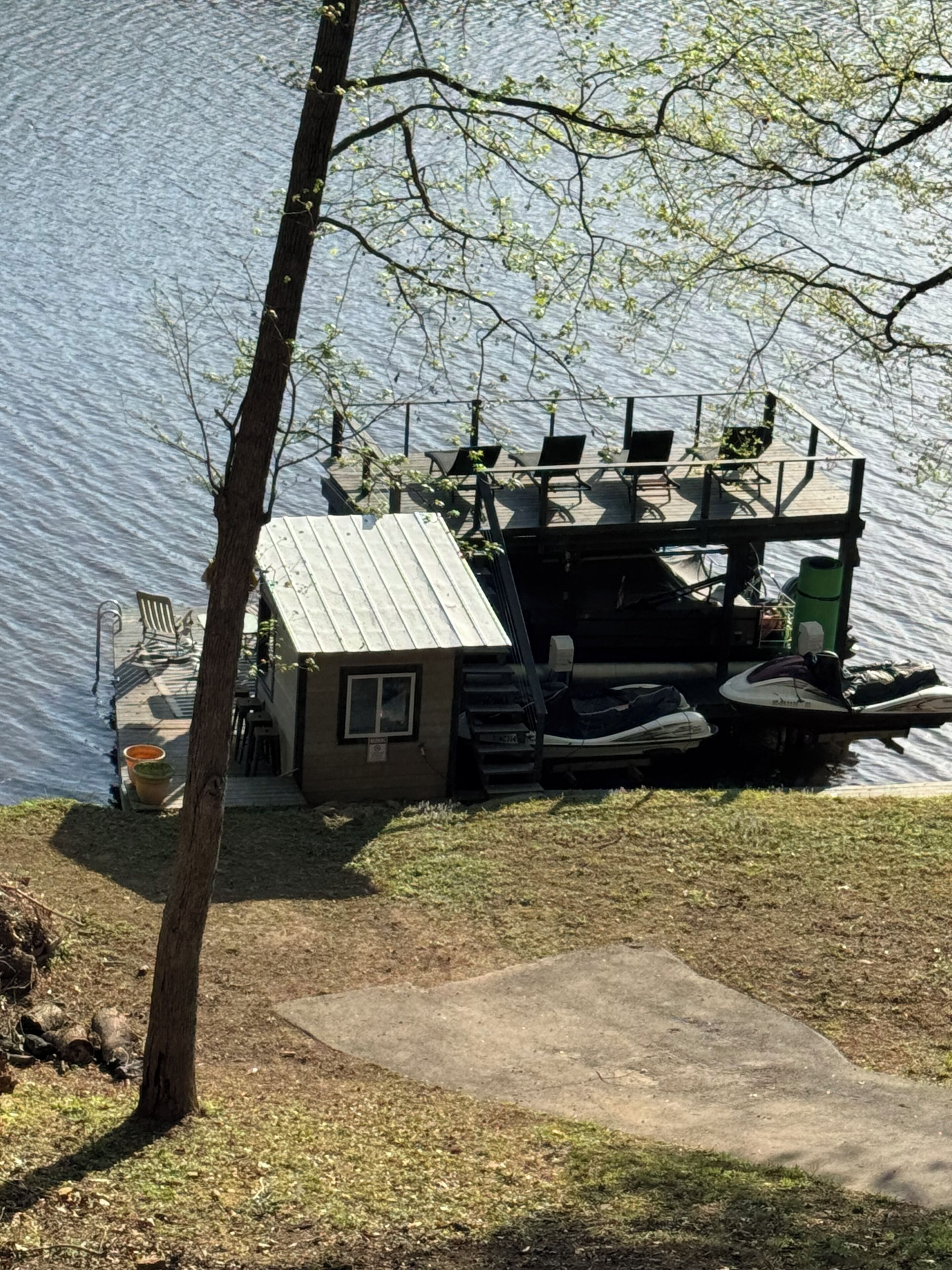 Eine Anlegestelle mit einem kleinen Gebäude, Sitzgelegenheiten im Freien und einem Boot.
