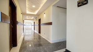 A long, well-lit hallway with a marble floor, wooden doors, and a sign indicating the 3rd floor and Jaguar J509-J514 rooms. - Treebo Jaguar Comforts, 3 Kms From Mahatma Gandhi Park (Chikkamagaluru)