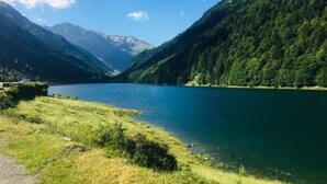 Un paysage de montagne avec un lac et une route qui descend vers la vallée.