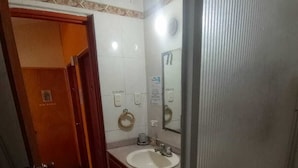 A bathroom with a toilet, sink, and mirror.