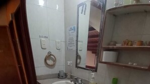 A bathroom with a toilet, sink, and mirror.