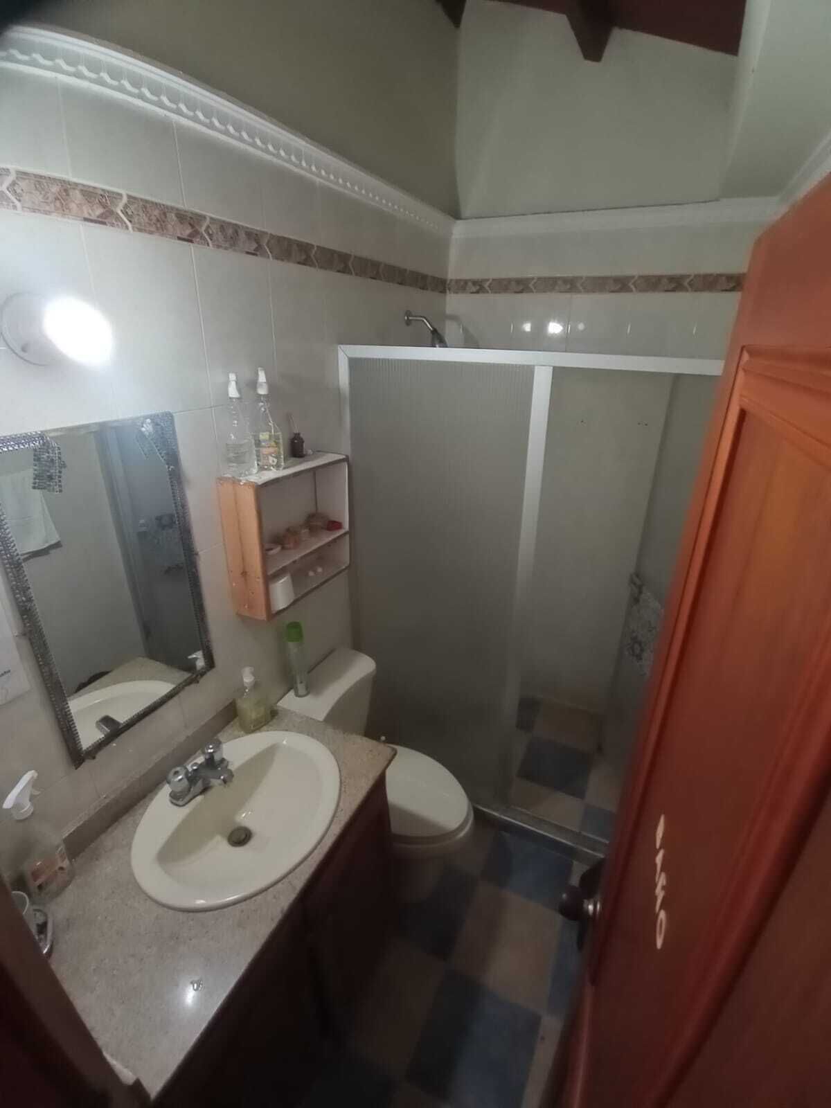 Une salle de bain équipée d’un lavabo, d’un miroir, de toilettes et d’une douche.