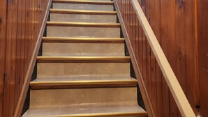 A wooden staircase with a handrail, leading to a door with a window. - Charming Family 1-level and pet-friendly Home (Austin)