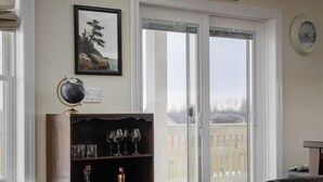 A living room with a dark wood bookshelf, a globe, and a framed picture on the wall. - River & Charm: 2 Homes, on 10 Acres Near Clayton (Clayton)