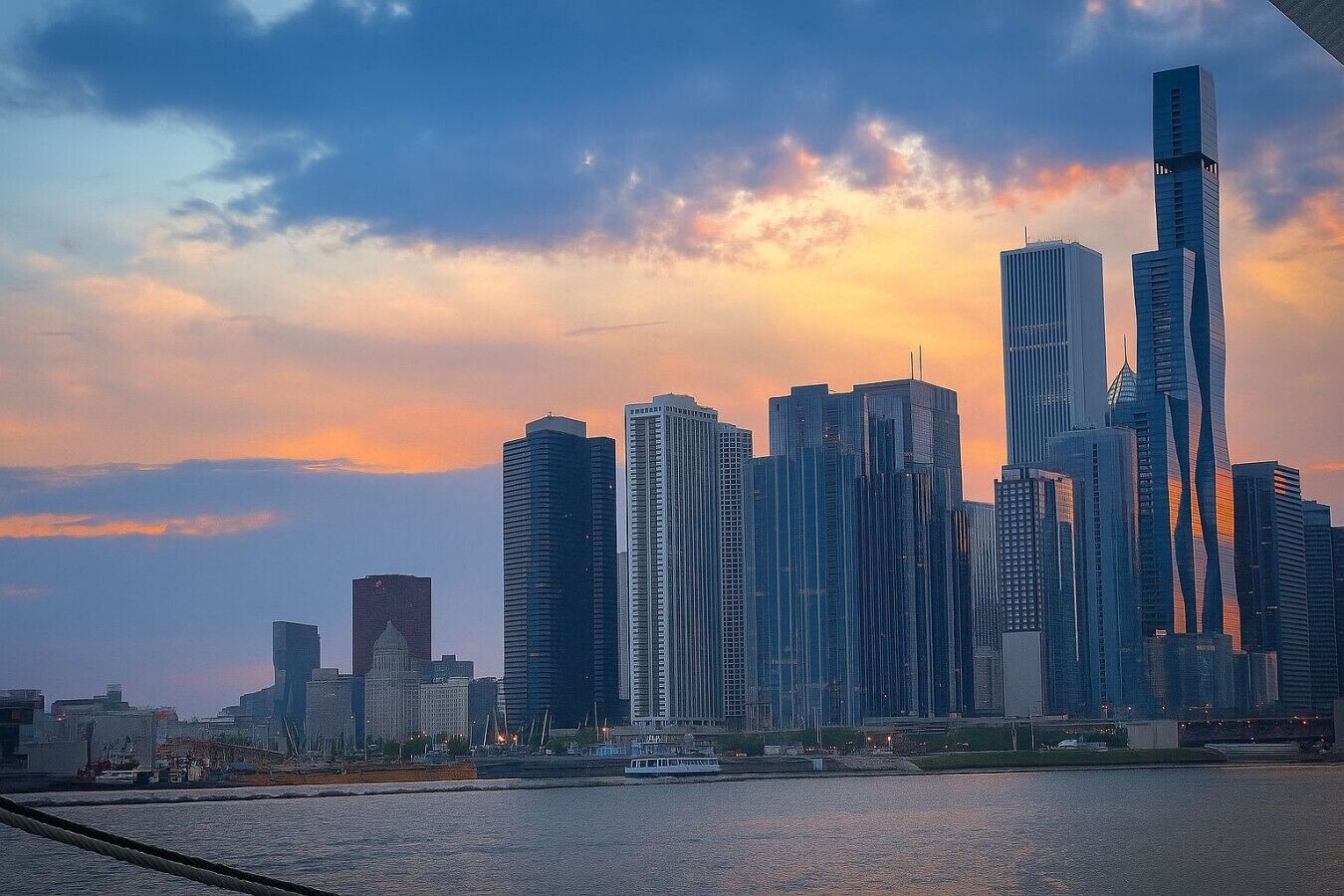 A city skyline with modern high-rise buildings and a river in the foreground.