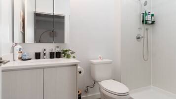 A modern bathroom with a toilet, sink, and shower.