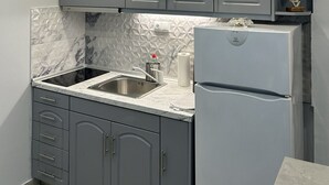 Una cocina moderna con armarios grises, un protector contra salpicaduras de mármol y un refrigerador empotrado.