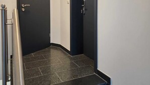 Een reeks zwarte trappen die leiden naar een donkere deur met daarboven het nummer 4.