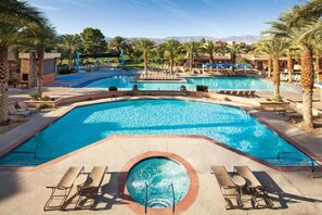 Relax by the pool surrounded by palm trees and lounge chairs.