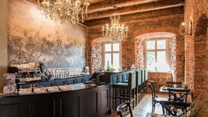 A rustic interior with a bar area, wooden beams, and a mural on the wall. - Zamek Sarny (Radkow)