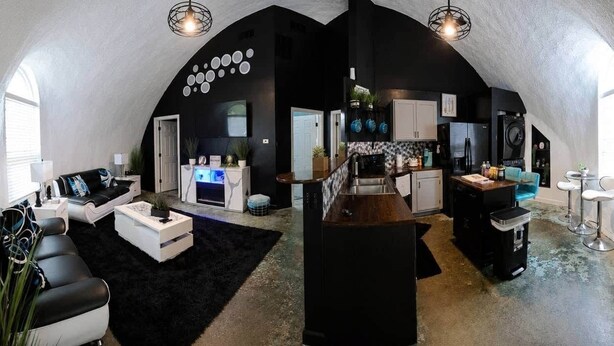 Un loft spacieux comprenant une cuisine, un espace de vie et un coin bar.