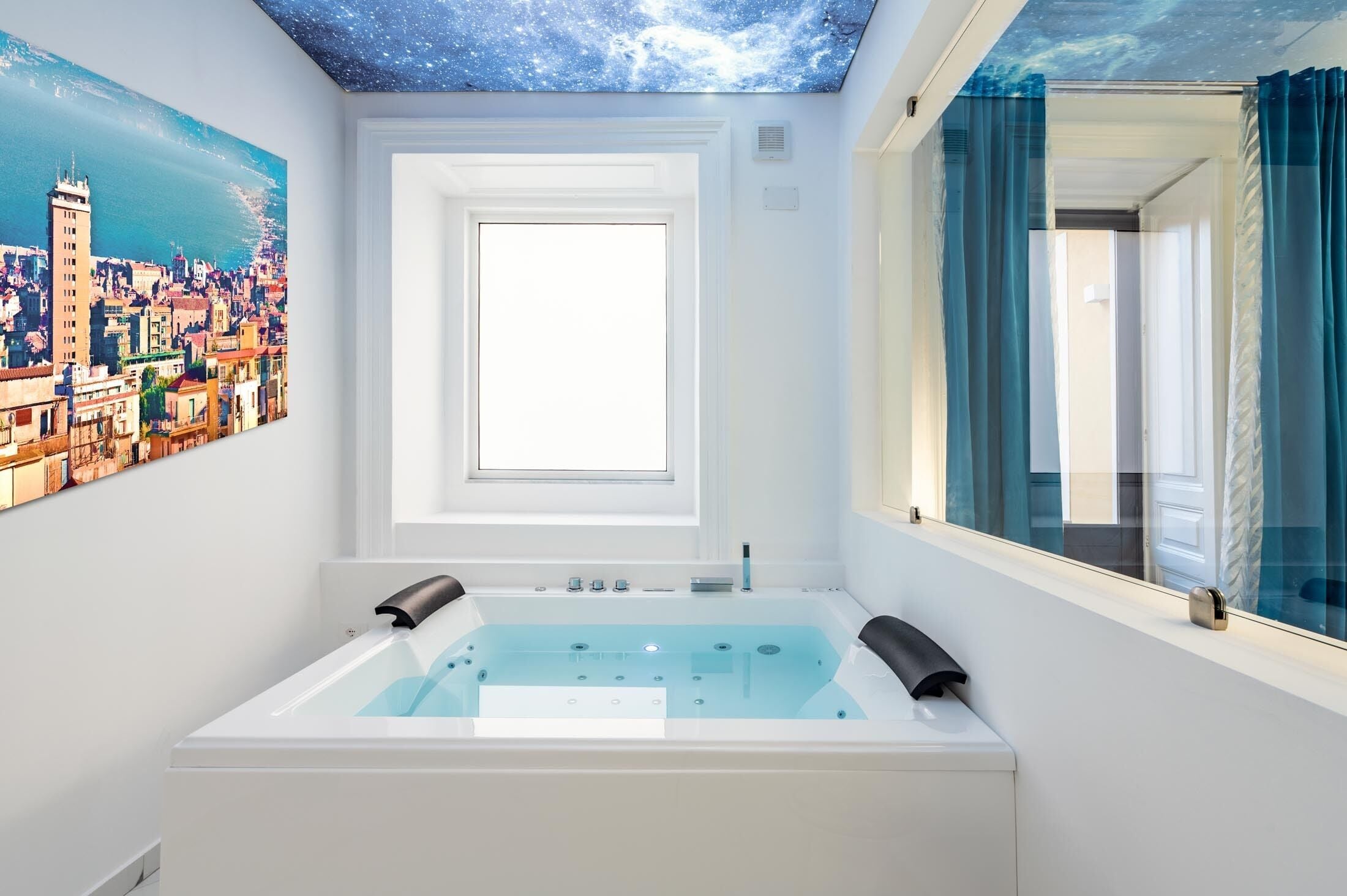 A modern bathroom with a large bathtub, a skylight, and a cityscape painting on the wall.