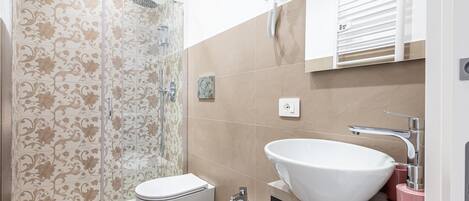A modern bathroom with a shower, toilet, bidet, and sink.