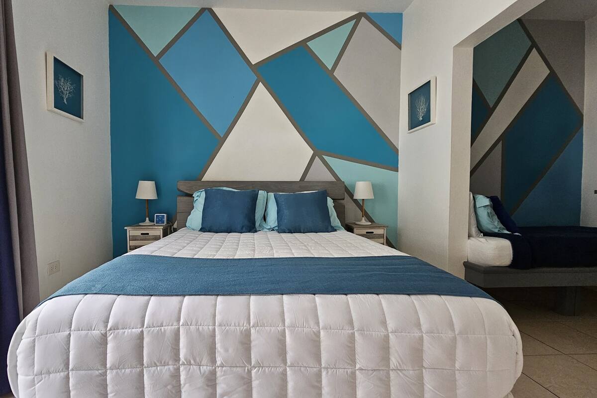 A bedroom with a bed, two bedside tables, and a nightstand.