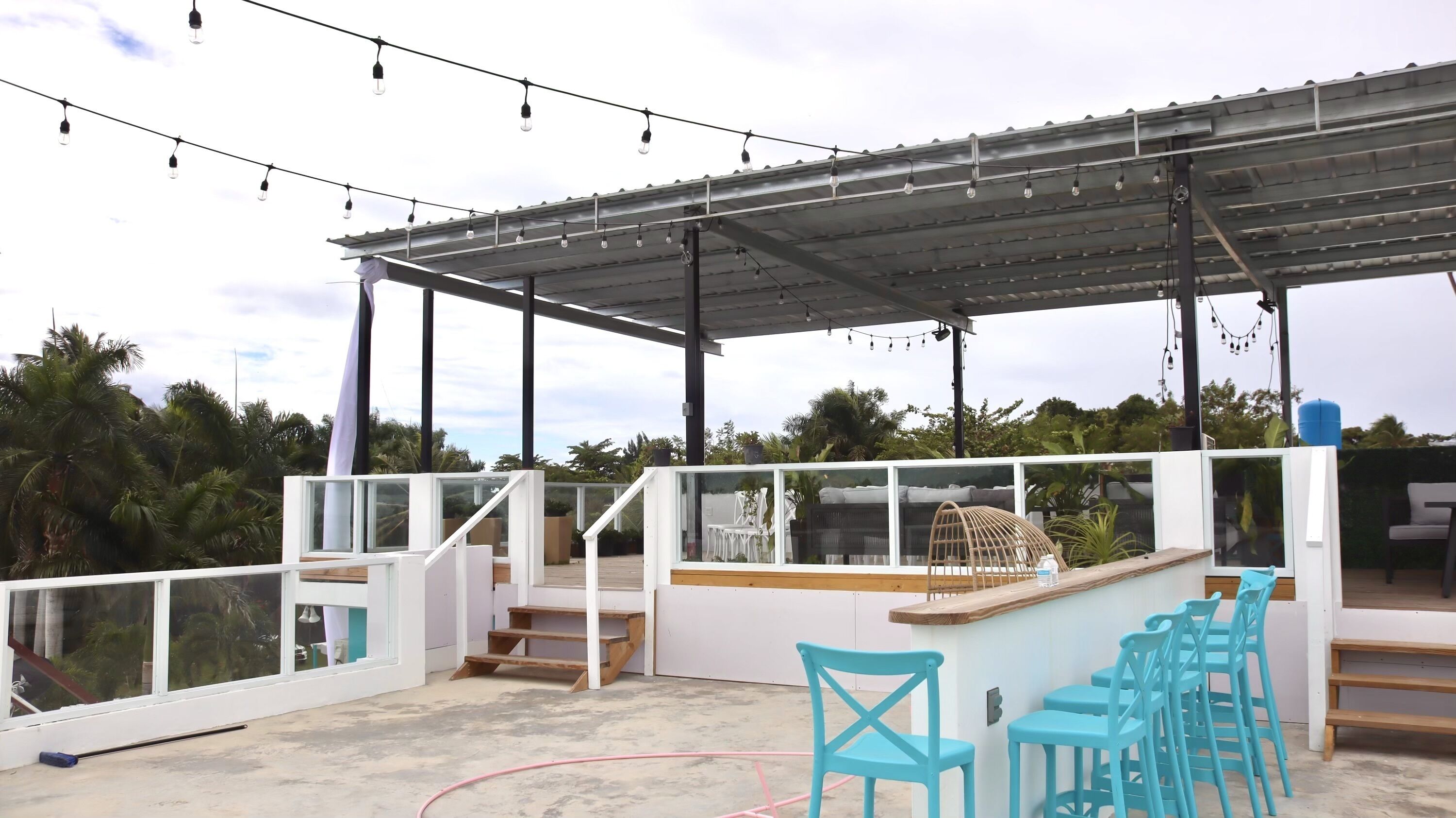 Un patio al aire libre con barra, asientos y una zona cubierta.