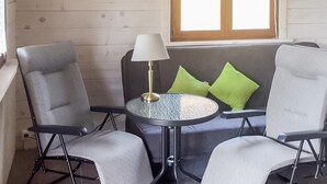 A seating area with two grey chairs, a small round table, and a lamp.
