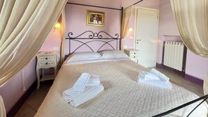 Ein Schlafzimmer mit einem Bett, einem Nachttisch, einem Heizkörper und einer Tür.