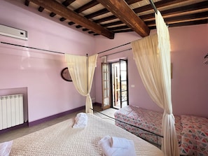Une chambre à coucher avec un lit, une fenêtre, un radiateur et un rideau.