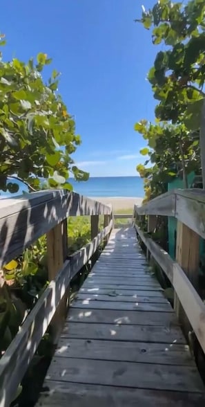 A wooden boardwalk leading to a beach.