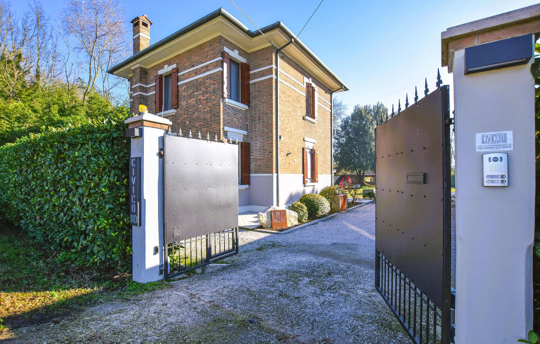 A gated entrance to a building with a brick facade and a metal gate.
