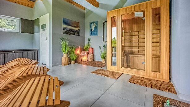 A spa room with wooden benches, a sauna, and a large wooden door. - Beautiful home in Taszów with sauna (Taszów)