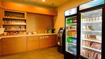 Un kiosque en libre-service équipé d’un distributeur de boissons et d’un compartiment réfrigéré contenant des collations et des boissons.