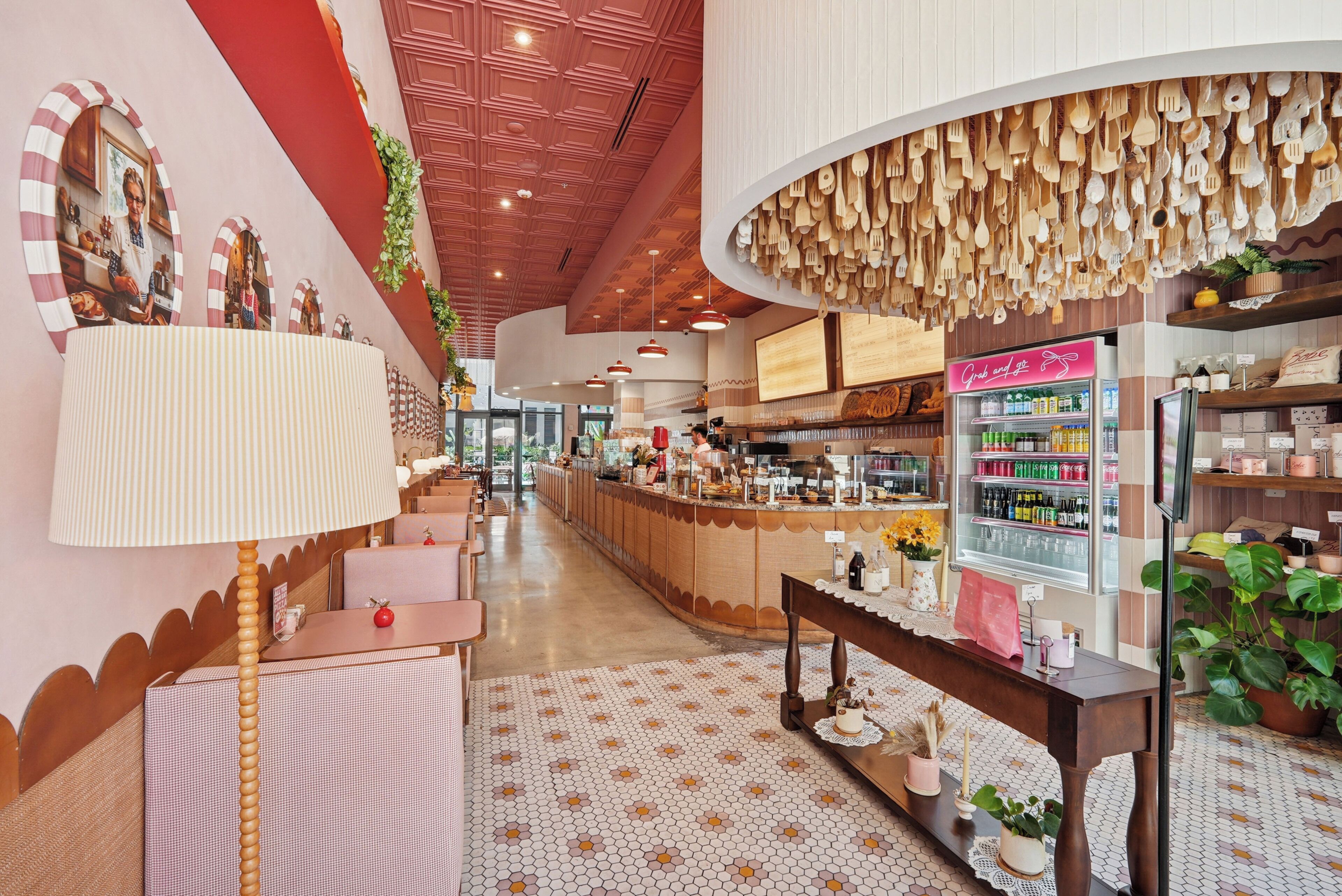 A restaurant interior with a central bar, seating areas, and a display of kitchen utensils.