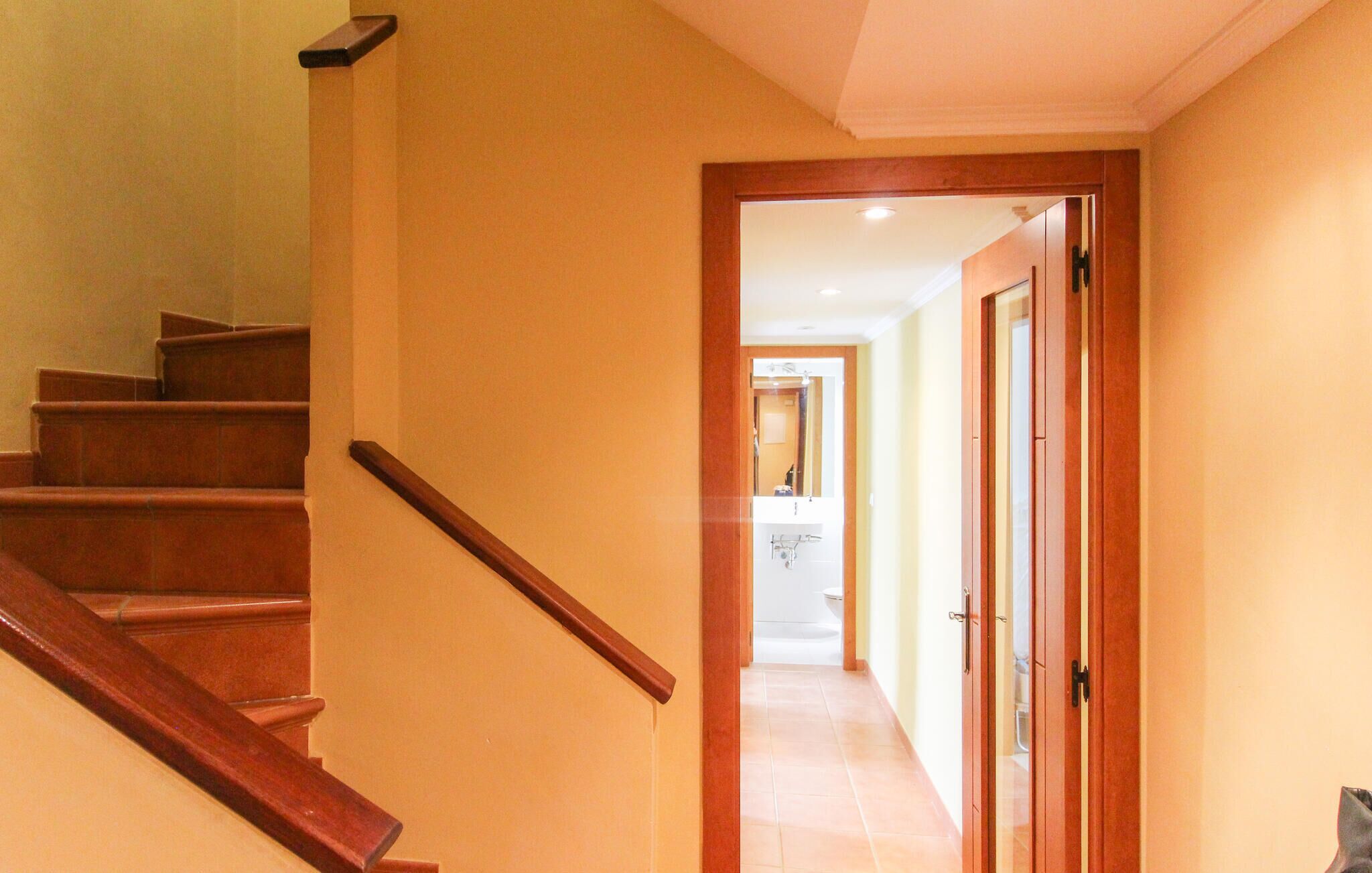 A staircase leading to a hallway with a door at the end.