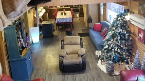 A cozy interior with a fireplace, leather sofas, a Christmas tree, and mounted animal heads on the ceiling. - Bathurst New Brunswick Access to snowmobiles trail and ATV. (Saint-Laurent)