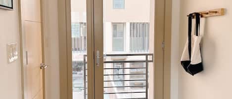 Ein Flur mit einer Doppeltür, die zu einem Balkon führt.