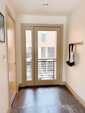 A hallway with a double door leading to a balcony. - Chic Apt w/parking - Walk to Capitol, Convention Center, museums & shops! (Denver)