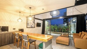 Ein moderner Wohnbereich mit einem Holzesstisch, zwei Stühlen, einem Sofa und einem Couchtisch.