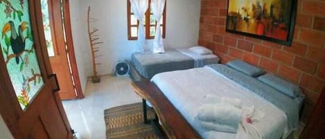 A bedroom with two single beds, a bench, a radiator, a window with curtains, and a painting on the wall.