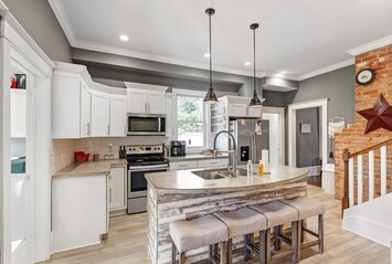 Modern Kitchen with Island Seating – Fully equipped kitchen with stainless steel appliances and bar seating.