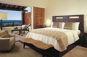Relax in a spacious bedroom with a large bed, seating area, and access to an outdoor space.