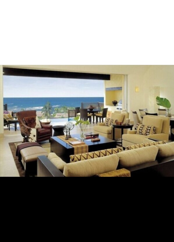 Relax in this ocean-view living room with a sofa set, coffee table, and dining area.