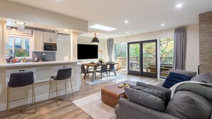 A modern kitchen with a dining area, a sofa, and a large sliding glass door to the outdoors. - Family-friendly Modern Cozy Downtown Mill Valley Unit in San Francisco Bay Area (Mill Valley)