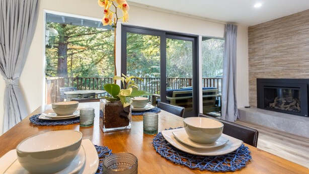 A dining table set with bowls, glasses, and a vase with flowers. - Family-friendly Modern Cozy Downtown Mill Valley Unit in San Francisco Bay Area (Mill Valley)
