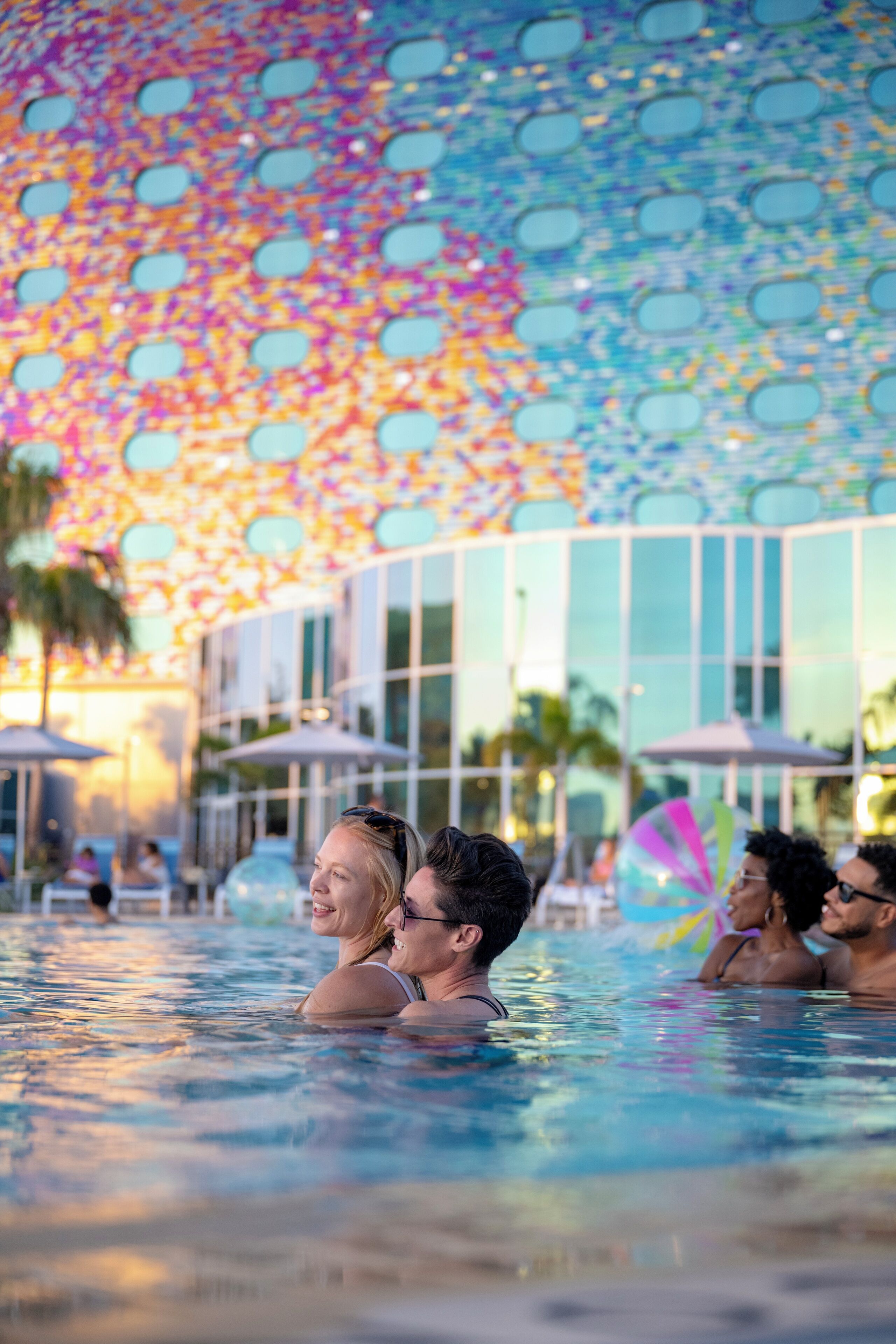 Una piscina al aire libre, sombrillas, sillones reclinables de piscina