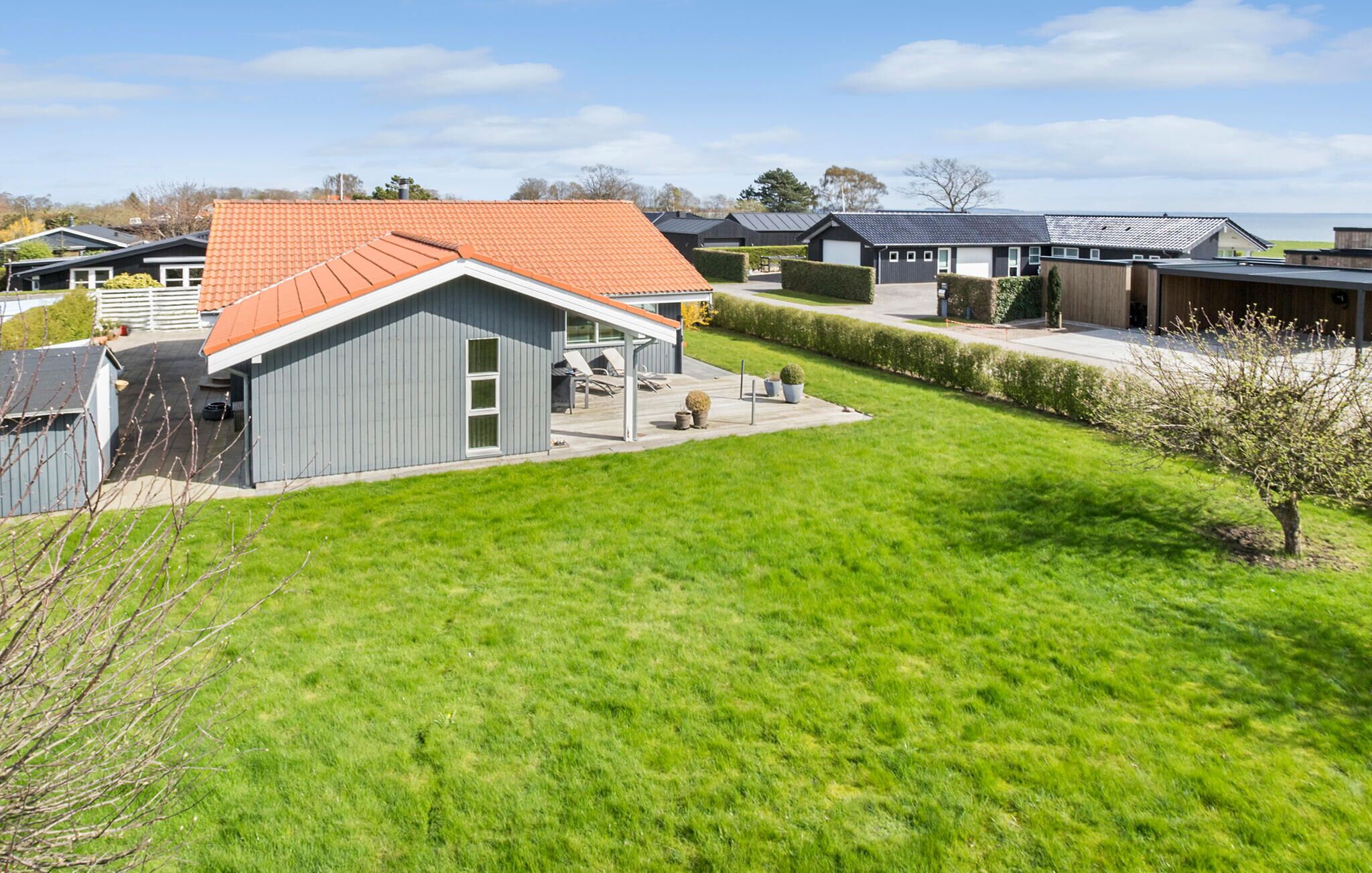 A residential area with houses featuring sloped roofs and a well-maintained lawn.