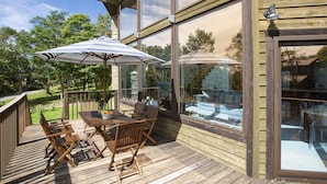 A wooden deck with outdoor furniture, a glass door, and a view of the surrounding landscape. - Casa La Mount by Elite Havens (Niseko)