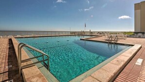 A rectangular swimming pool with clear blue water, surrounded by a brick deck and metal railings. - Beachfront on no-drive beach.  Park & walk to local spots.   (New Smyrna Beach)