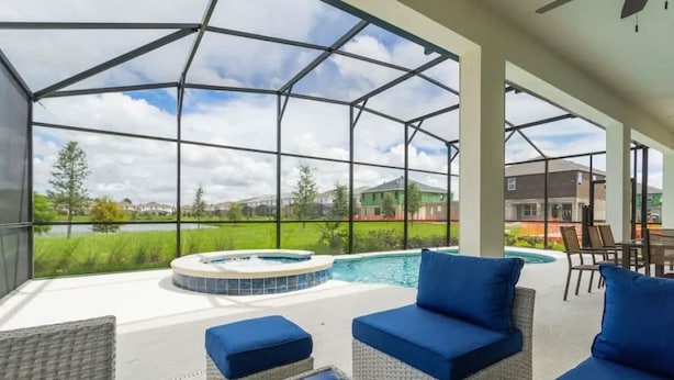 Eine Außenpatio mit Korbmöbeln, einem Whirlpool und Blick auf eine Wohngegend.