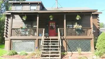 Step up to the charming entrance of this cozy cabin, featuring a covered porch and beautifully landscaped garden.