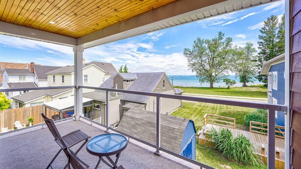 A balcony with a view of a lake and houses. - Cottage featuring Lake view balcony, private elevator and 3 en-suites! (Fort Erie)