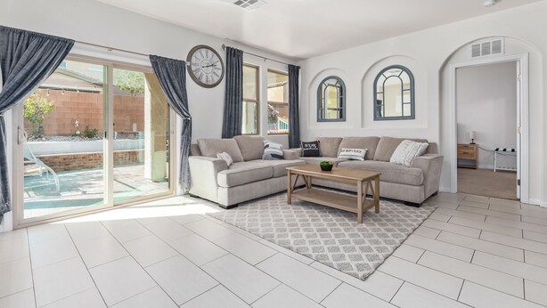 A spacious living room with a large sofa, a coffee table, and a view of the outside. - ⭐️ Cozy Vegas Home - Close to Strip - 5 ⭐️ (Las Vegas)